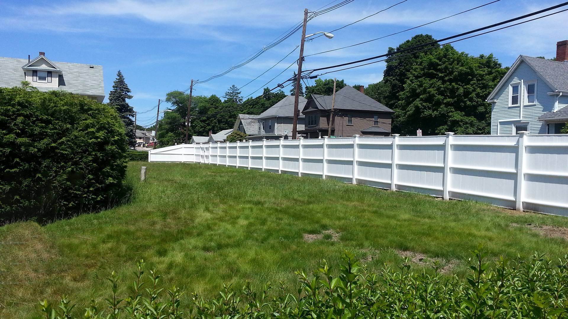 The curving white vinyl fence A white privacy vinyl fence curving through a suburban landscape with houses
