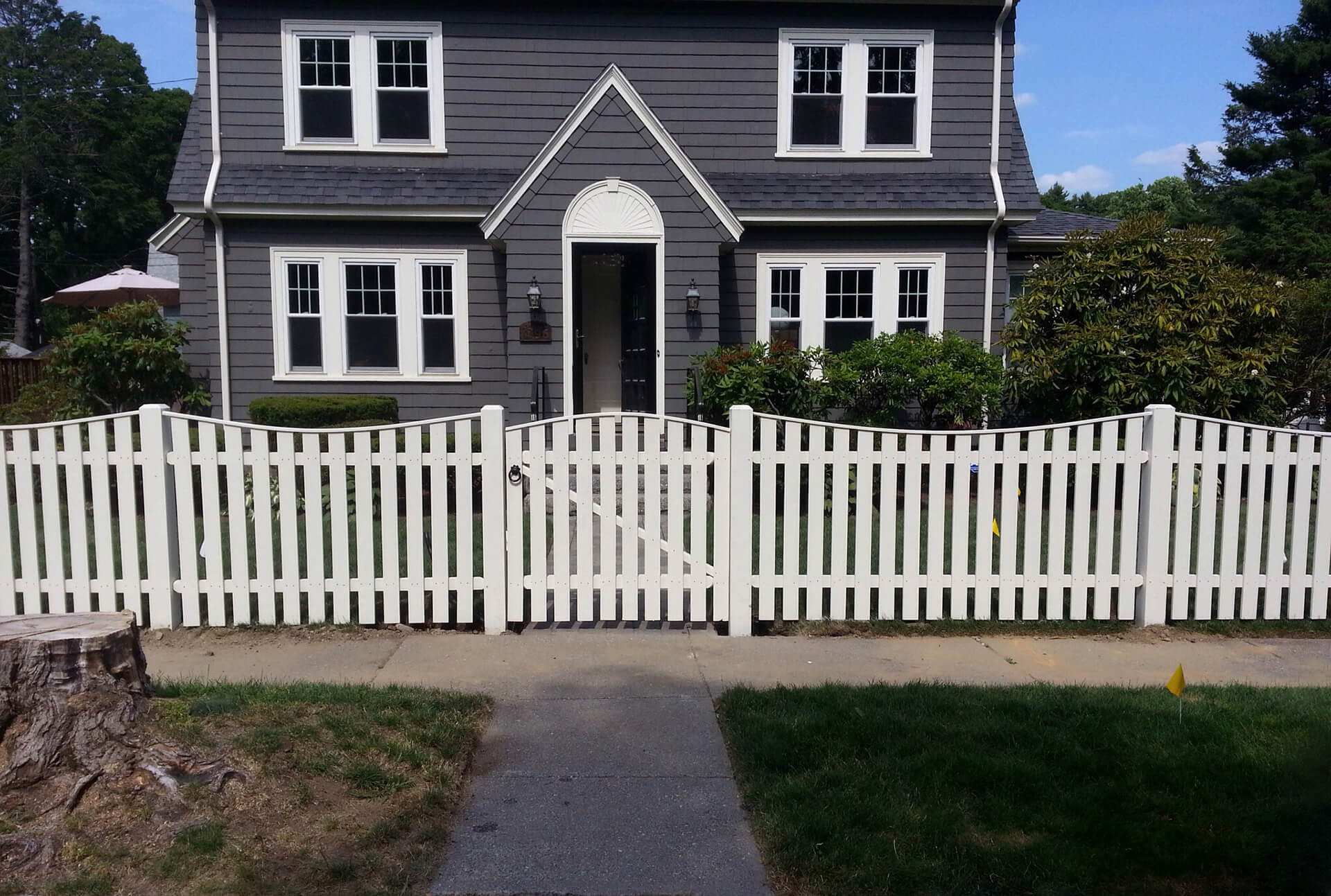 A white picket fence surrounds a charming house, enhancing its inviting and classic appearance.