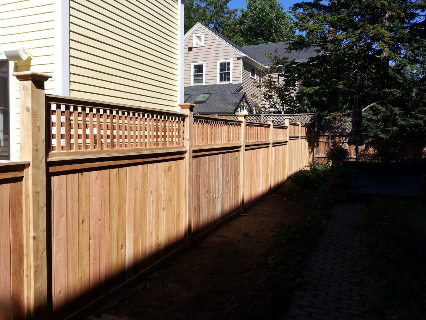 A wooden fence featuring a lattice design at the top, providing an elegant and decorative touch to the structure.